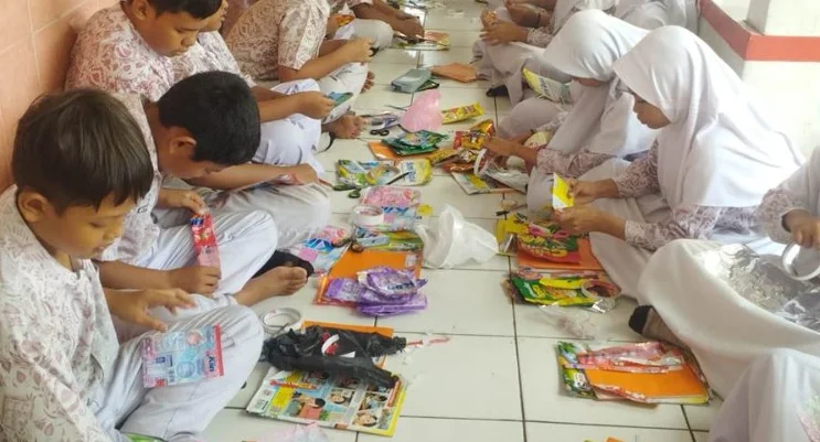Peserta didik kelas V membuat karya seni bunga dari limbah bungkus kemasan rumah tangga.
